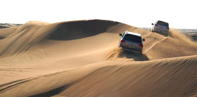 Cars driving on sandy dunes